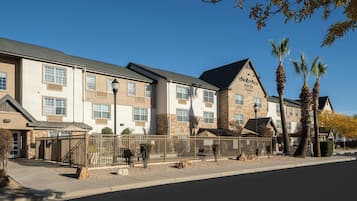 A hotel with a stone facade, multiple windows, and a sign indicating 'TOWNEPLACE SUITES.'