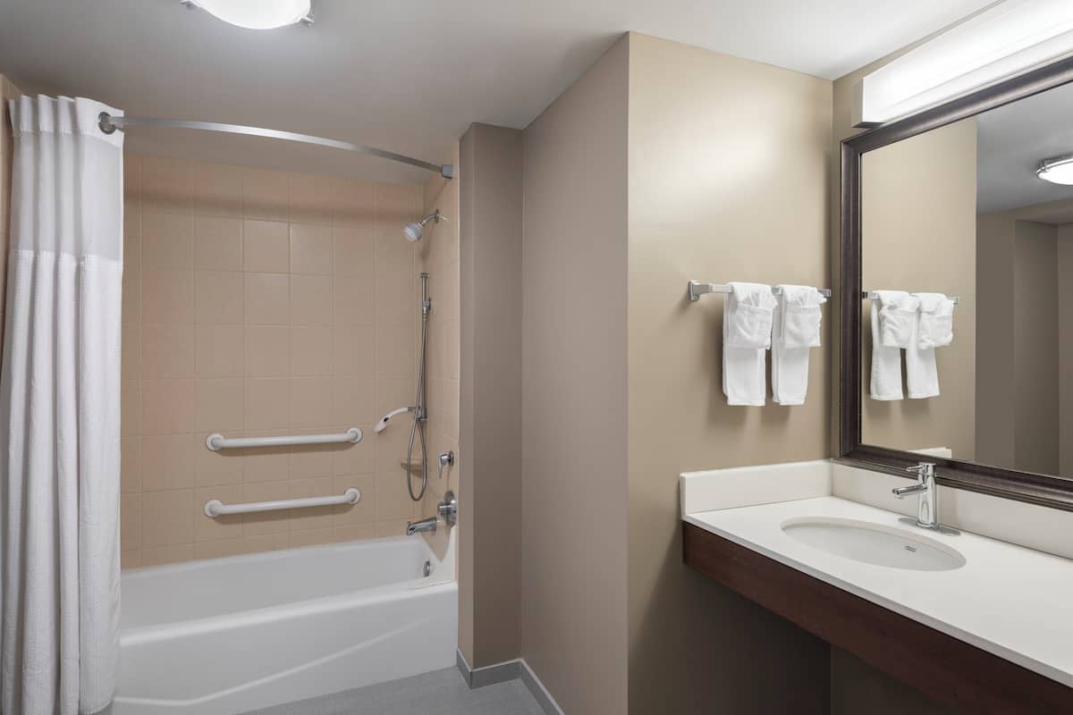 Un baño moderno con bañera, ducha y lavabo.