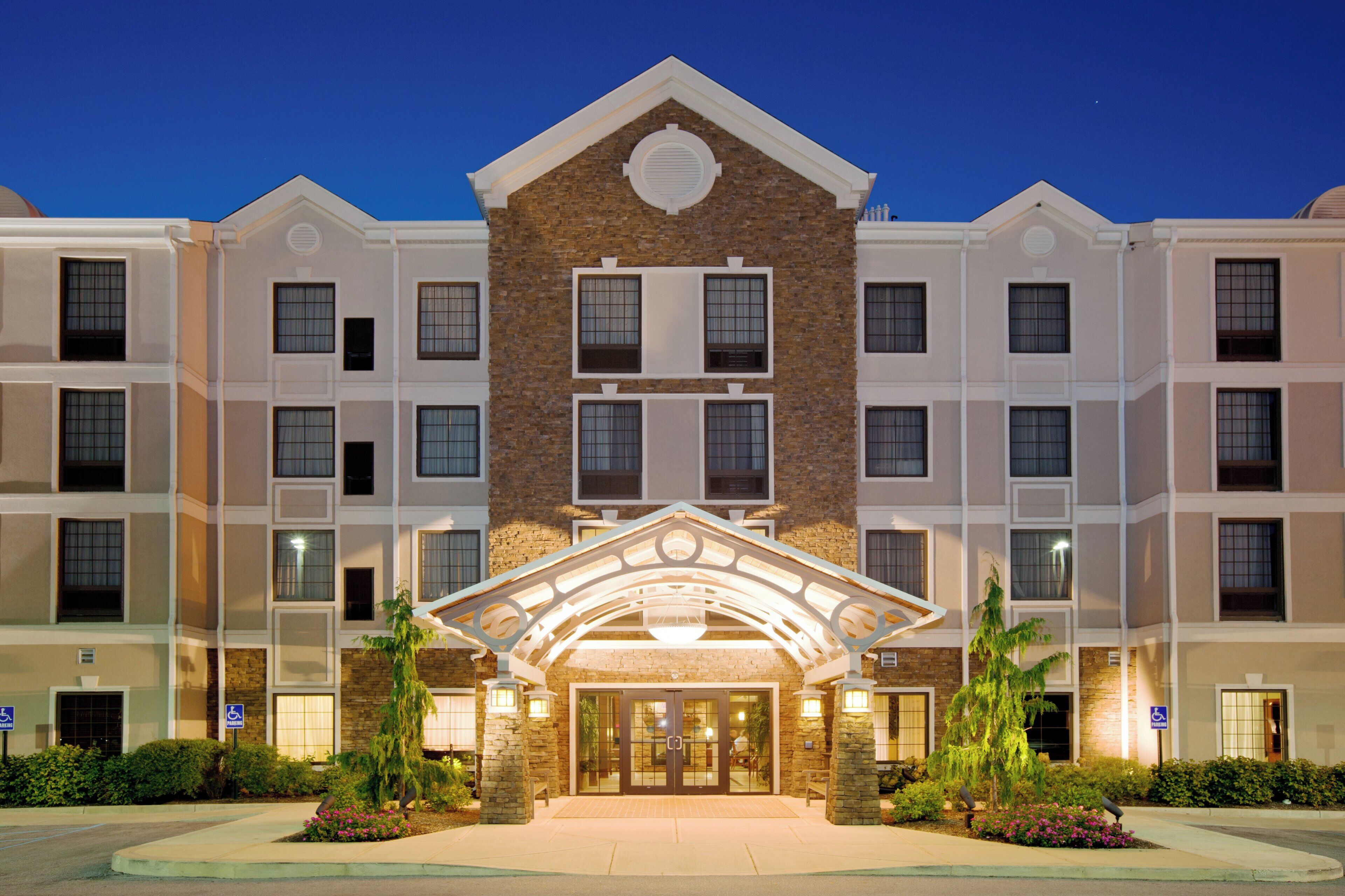 A multi-story hotel with a central entrance, a brick facade, and uniform window patterns.