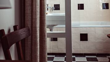 A bathroom with a checkered floor, a white sink, and a bathtub.
