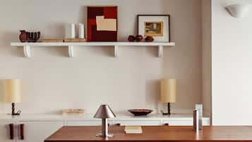 A modern kitchen with white cabinetry, a wooden countertop, and a hanging shelf with decorative items.