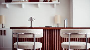 Uma área de bar moderna com dois banquetas e um balcão central.