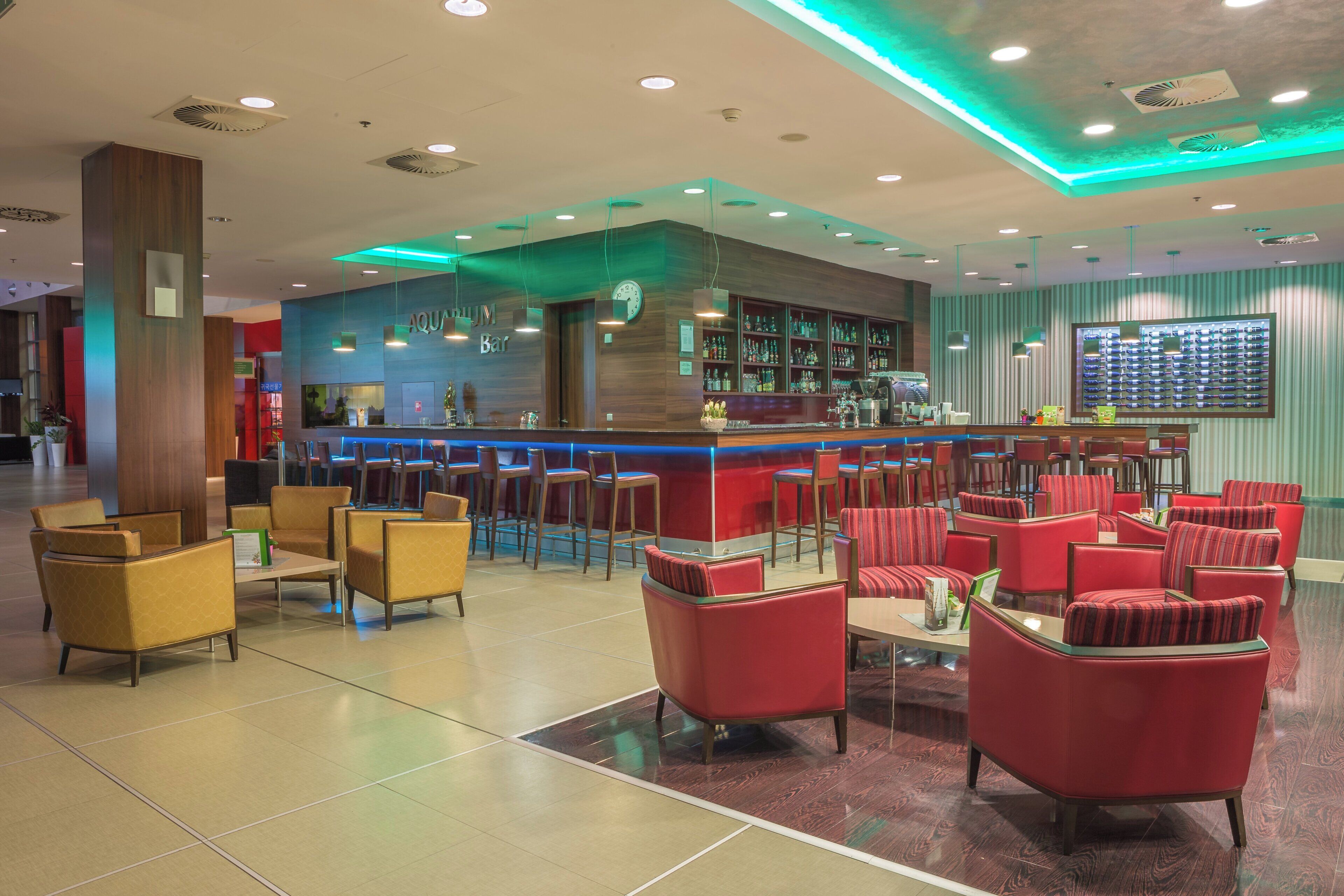 A bar area with a counter, seating, and a clock.