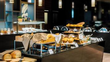 Una mesa de buffet con diversos productos de pastelería y bollería.