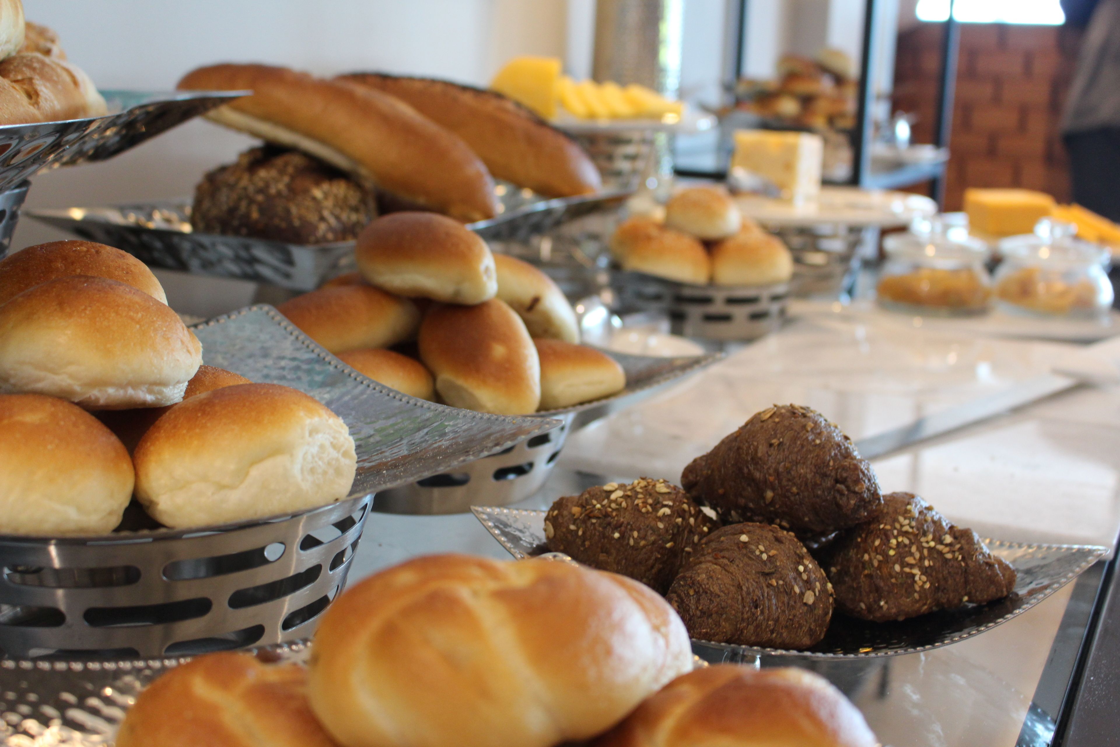 A buffet with various breads and pastries.