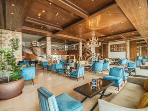Eine großzügige Lobby mit einer imposanten Treppe, mehreren Sitzbereichen und einem Chandelier.