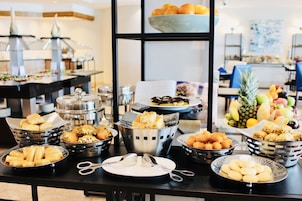 Una mesa de buffet con diversos alimentos y utensilios.