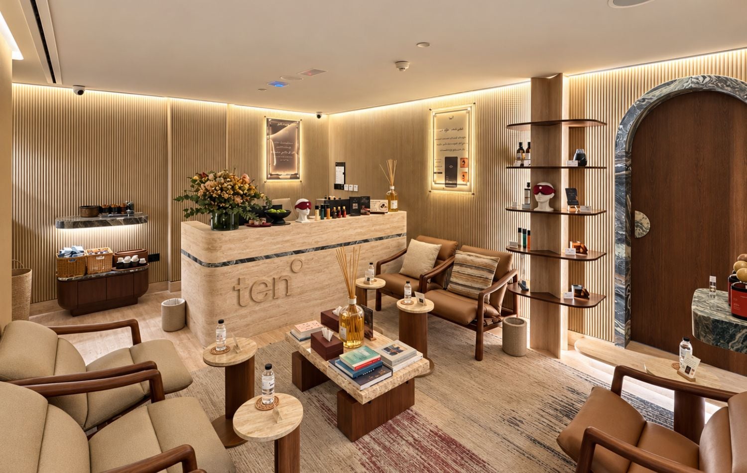 A modern lounge area with a reception desk, seating, and a bookshelf.