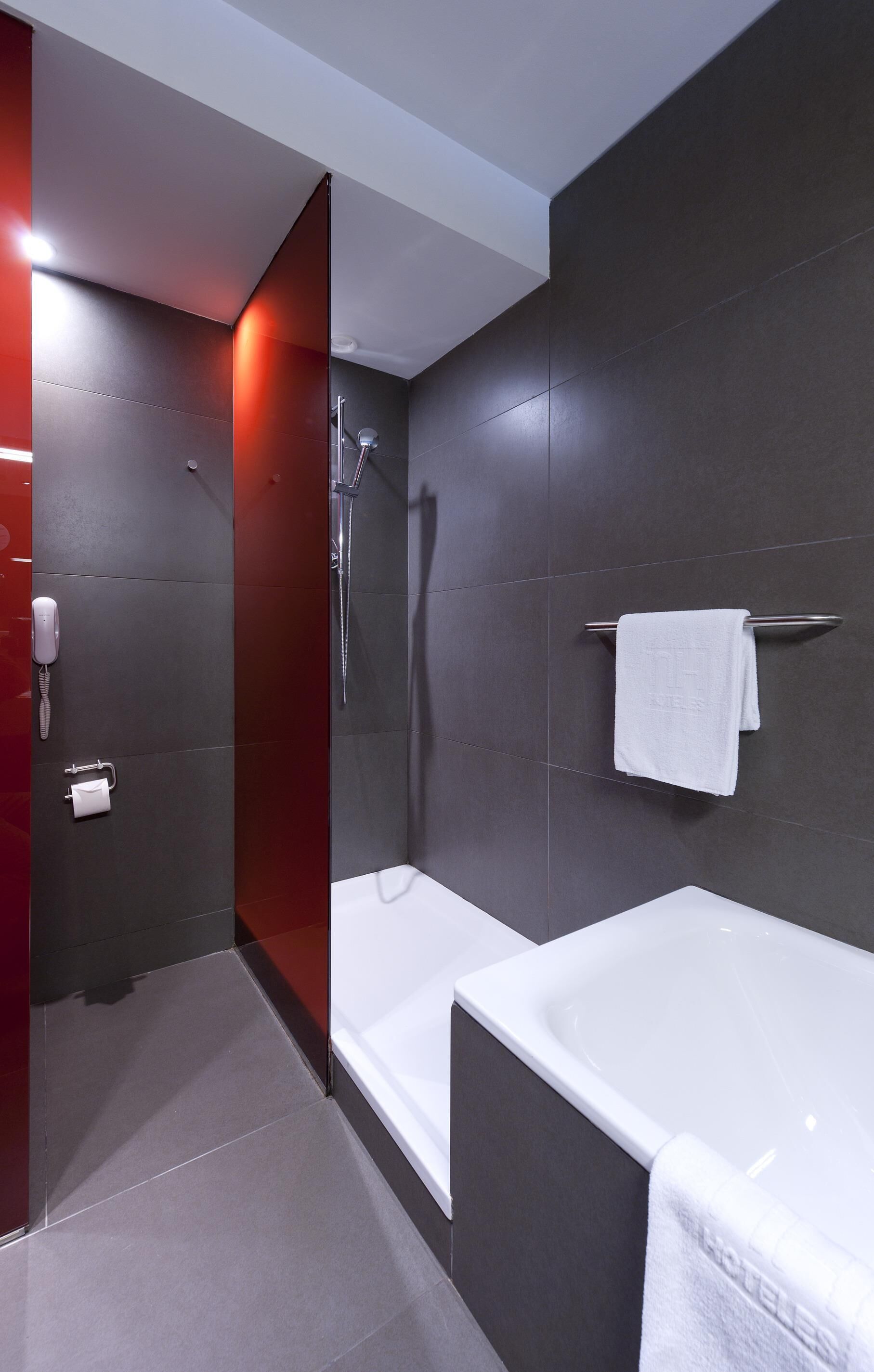 Un baño moderno con ducha, bañera y retrete.