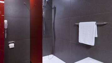 Un baño moderno con ducha, bañera y retrete.