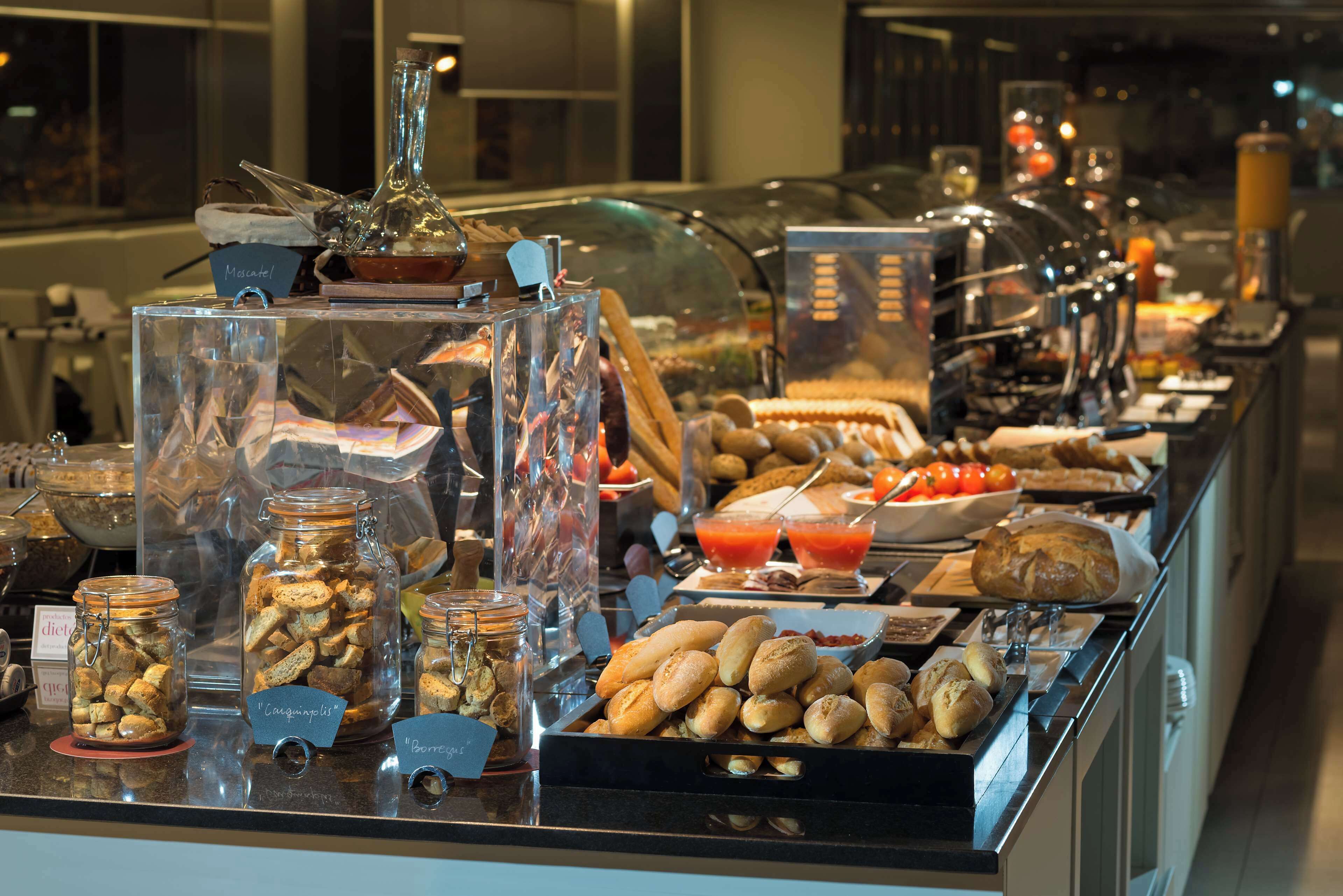 A buffet with various food items, including bread, pastries, and condiments.