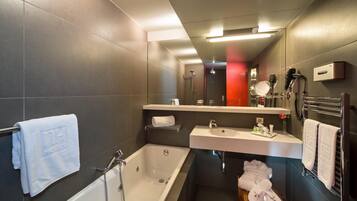 A modern bathroom with a bathtub, a sink, and a mirror.