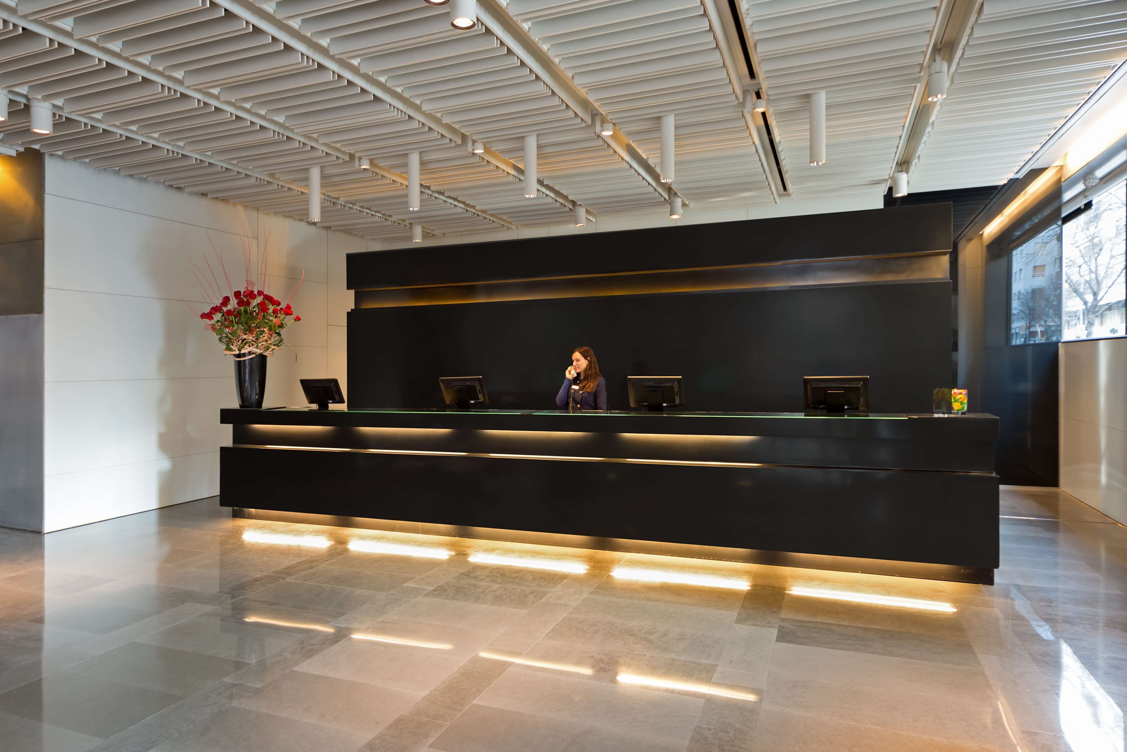 A modern reception desk with a black counter and integrated lighting.