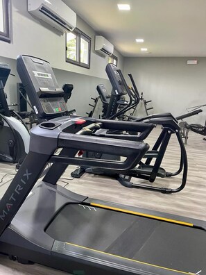 A gym with treadmills, stationary bikes, and weight machines. - Fiesta Royale Hotel (Accra)
