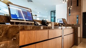 A reception desk with a computer, phone, and a small counter. - Fiesta Royale Hotel (Accra)