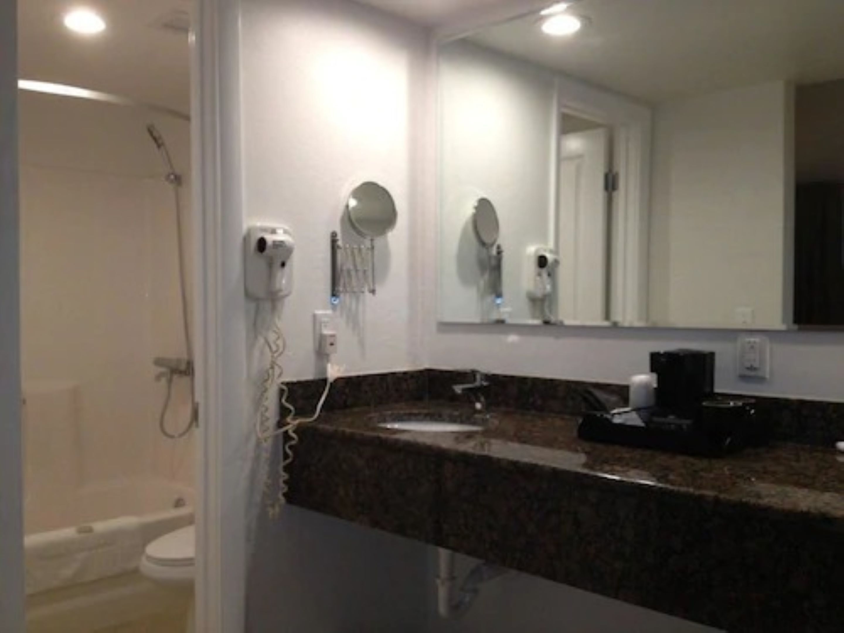 Un bagno con lavandino, specchio e doccia.