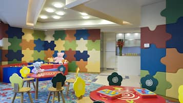 Children can play and learn in this vibrant play area with a colorful puzzle wall, play table, and toy storage.