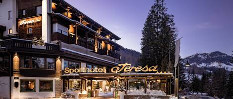 Et hotel med et skilt, der viser "Sporthotel Teresa", og en snebelagt indgang.
