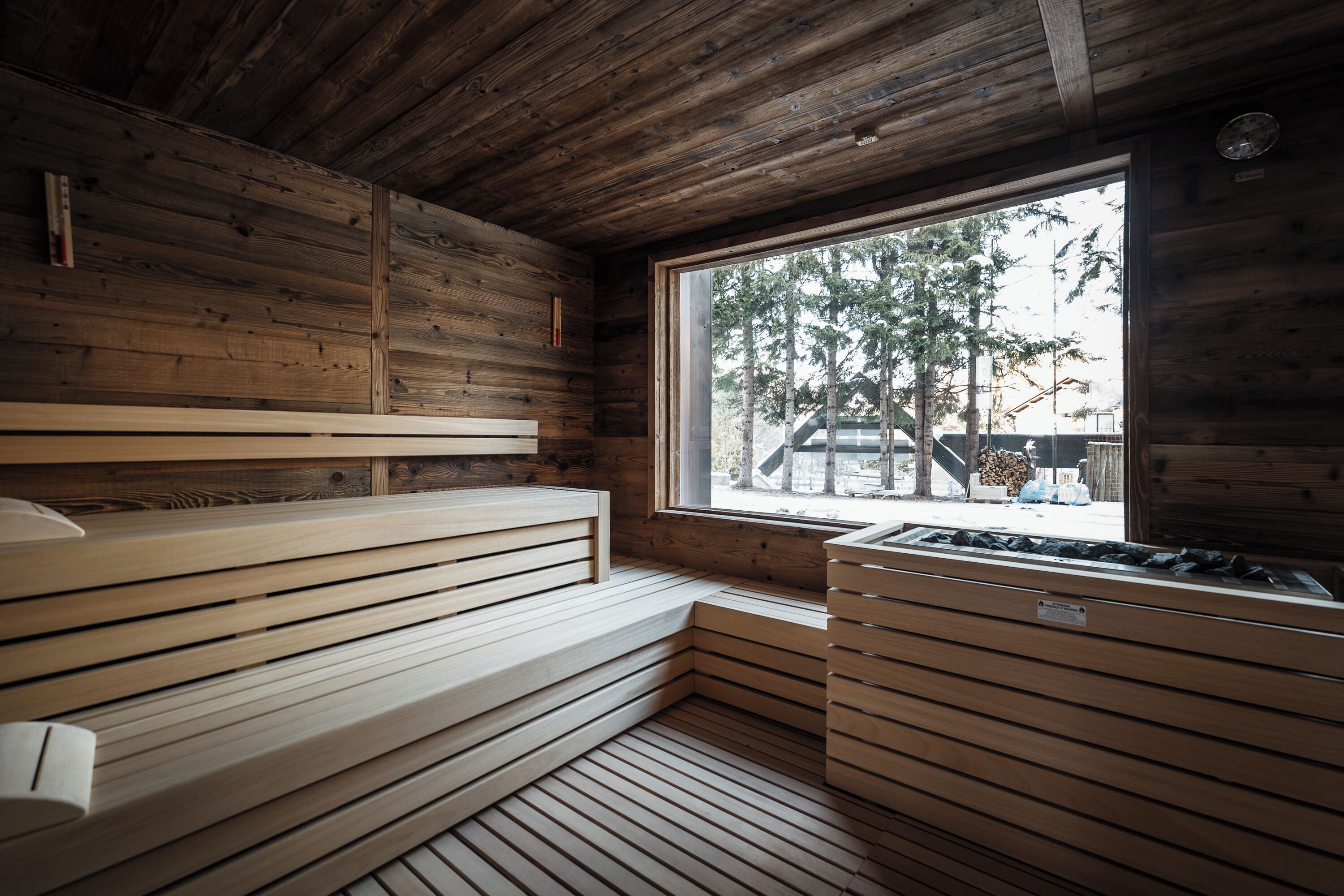 A wooden sauna with benches and a window.