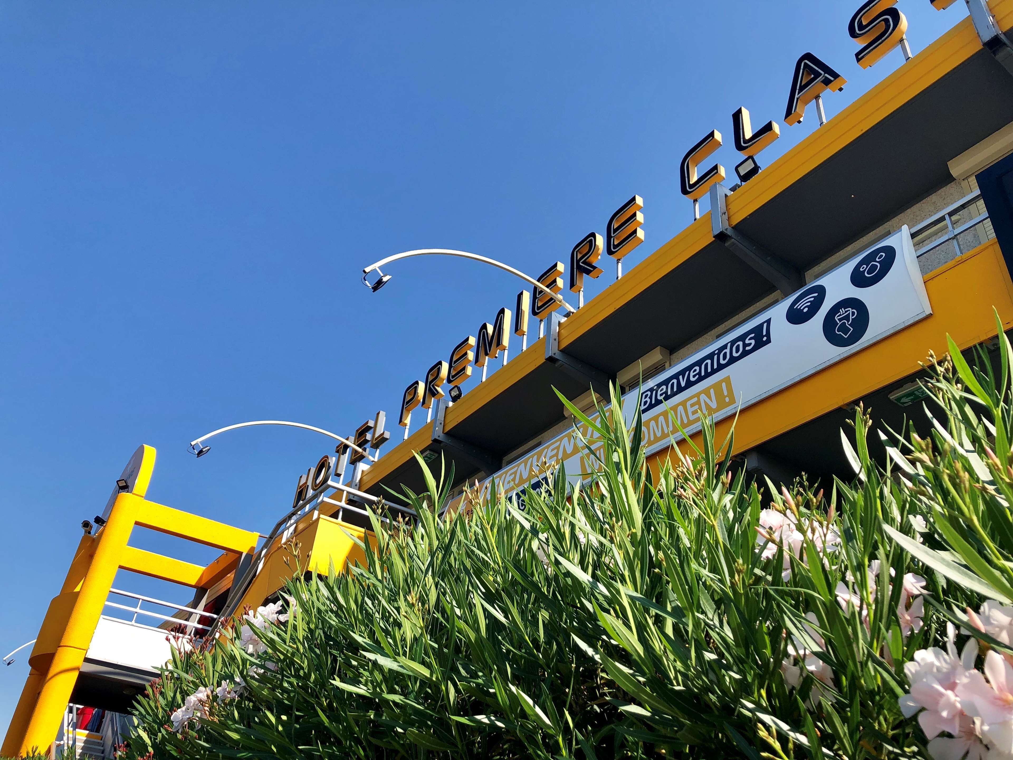 A hotel entrance with a prominent sign reading "HOTEL PREMIERE CLASS".