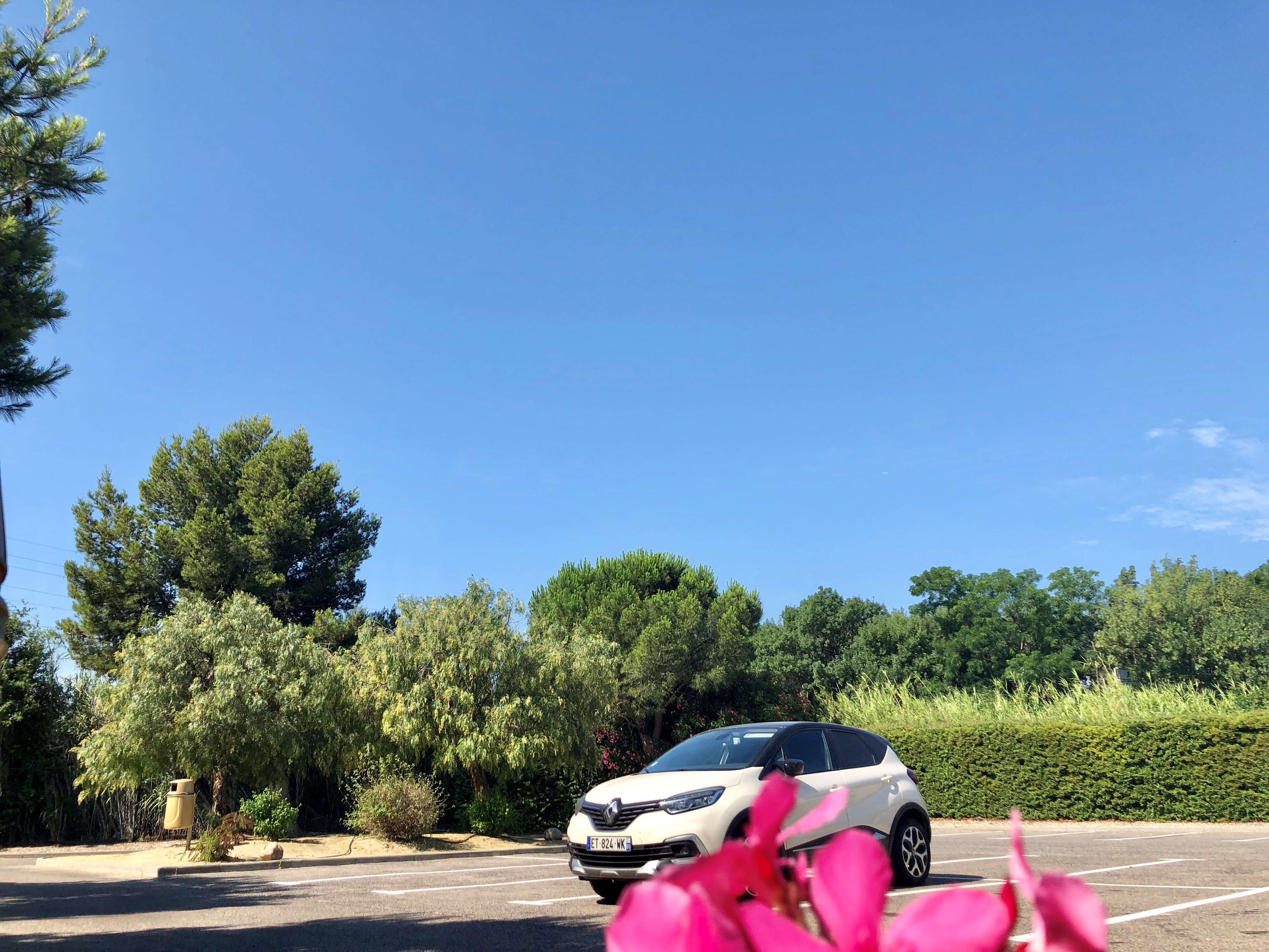 A parking lot with a white car parked in the foreground.