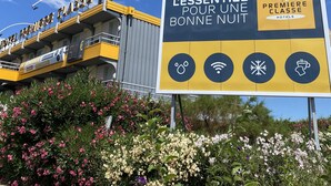 Un letrero de hotel con iconos que representan servicios, incluyendo Wi-Fi, ducha, nieve y una bebida.