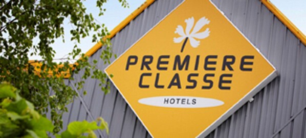 A yellow sign with the text "PREMIERE CLASSE HOTELS" and a white maple leaf symbol.