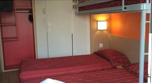 Ein Stockbett mit roter Bettwäsche, ein weißer Kleiderschrank und eine Wandleuchte.