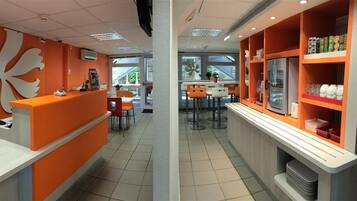 Un intérieur moderne comprenant un comptoir d’accueil, un espace détente et un réfrigérateur.