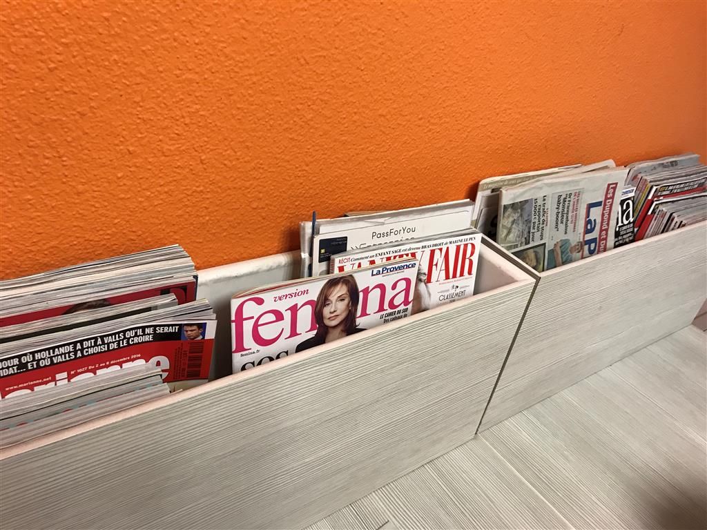 Un présentoir à magazines contenant divers périodiques, dont un numéro du magazine « femenina » mis en évidence.
