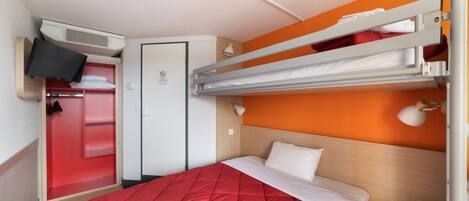 Una habitación de hotel con literas, televisión, armario y escritorio.