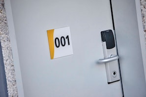 A door with a number plate labeled '001' and a keyhole. - Premiere Classe Avignon Sud - Parc des Expositions (Avignon)