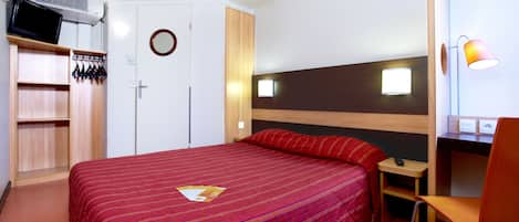 Une chambre d’hôtel comprenant un lit, un bureau, une chaise, une armoire et un téléviseur.