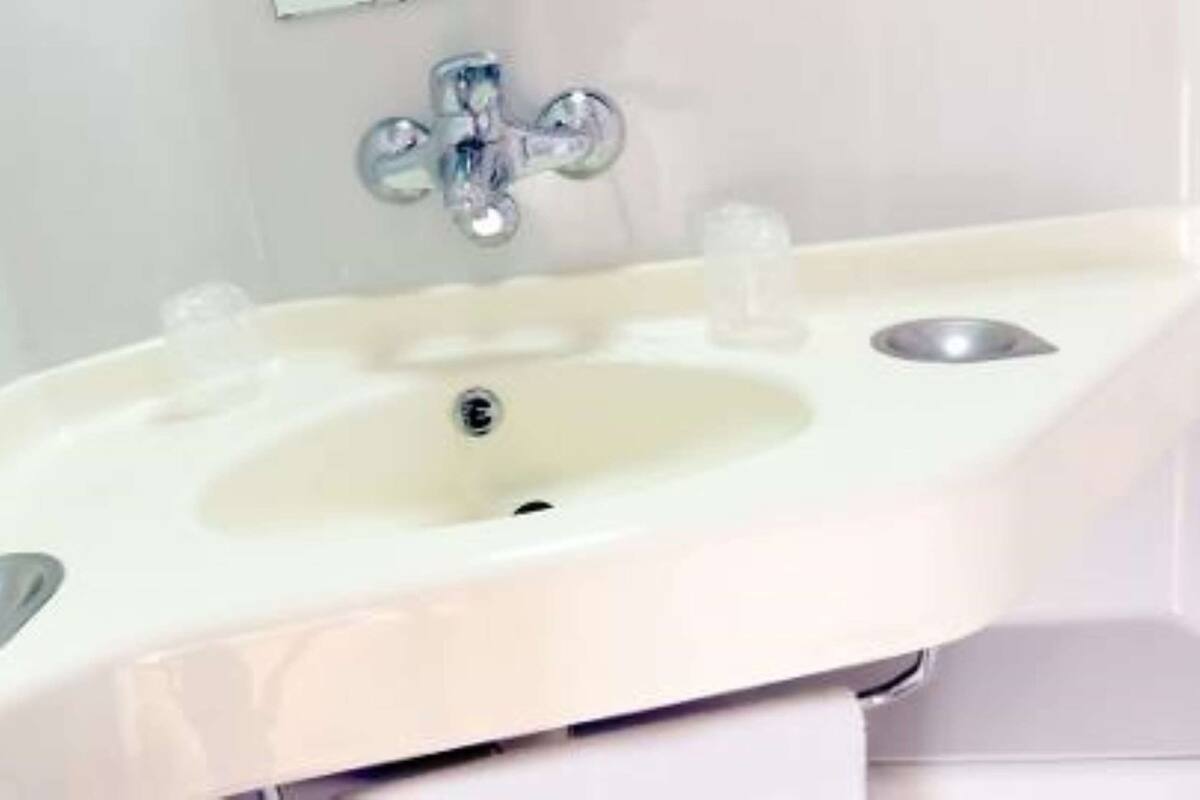 Ein Waschbecken mit einem Chrom-Wasserhahn und einem Abfluss.