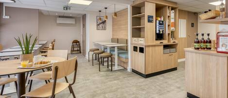 A cafe with wooden furniture, a counter with condiments, and a plant.