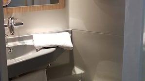 A bathroom with a sink, mirror, and toilet. - Premiere Classe Lyon Est - Aéroport Saint Exupéry (Saint-Laurent-de-Mure)