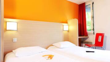 A hotel room with two beds, a red chair, and a window with curtains.