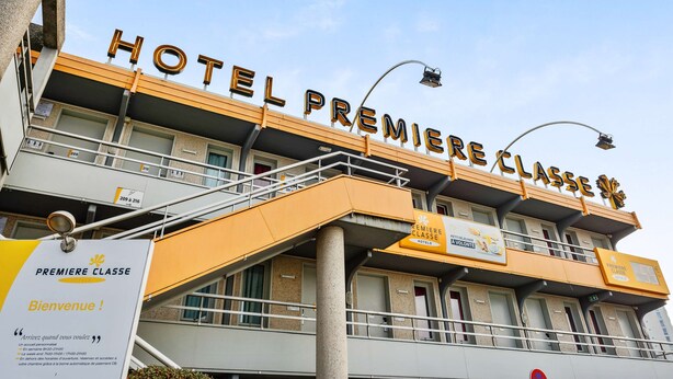 Un hôtel appelé « HOTEL PREMIERE CLASSE », avec une enseigne indiquant « Bienvenue ! » et un message d’accueil.