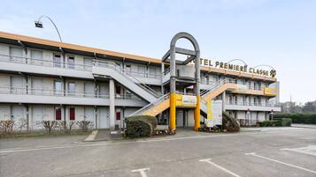 A hotel with a prominent entrance, multiple balconies, and a distinctive yellow and gray color scheme.