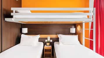 Een slaapkamer met stapelbedden, een nachtkastje met een lamp en een raam met oranje gordijnen.