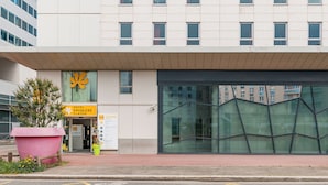 A hotel entrance with a large glass facade, a check-in desk, and a sign indicating a 'Premier Classe' room. - Premiere Classe Lyon Centre - Gare Part Dieu (Lyon)