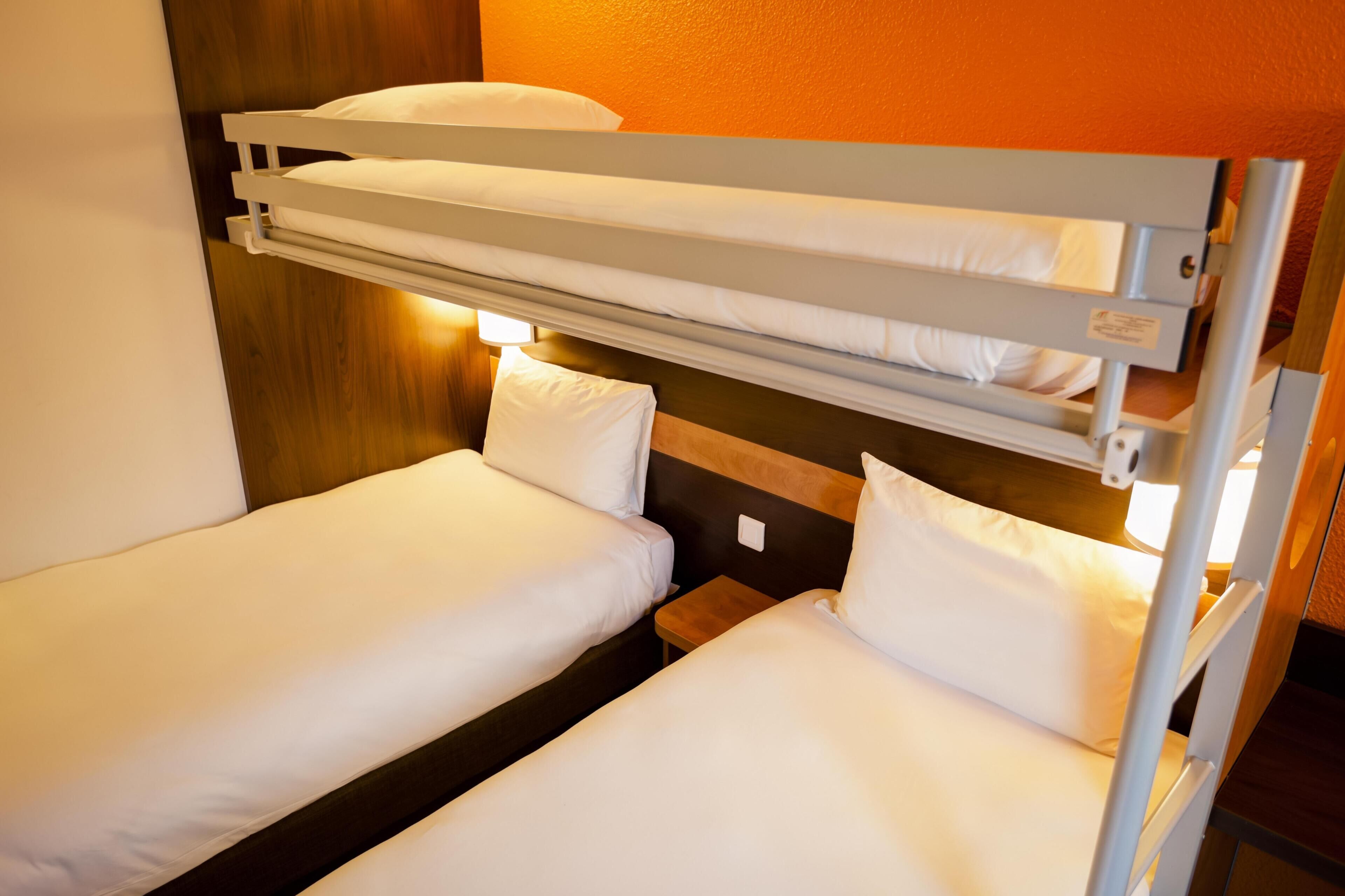 A bunk bed with two levels, each with a pillow and a headboard.