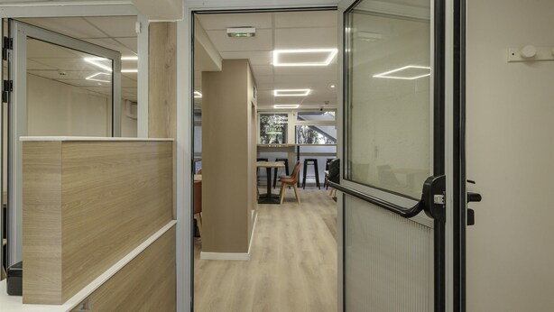 An office space with cubicles, a meeting area, and a view of the outdoors. - Premiere Classe Toulon - La Seyne sur Mer (La Seyne-sur-Mer)
