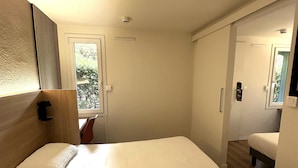 A bedroom with two beds, a window, and a wardrobe. - Premiere Classe Toulon - La Seyne sur Mer (La Seyne-sur-Mer)