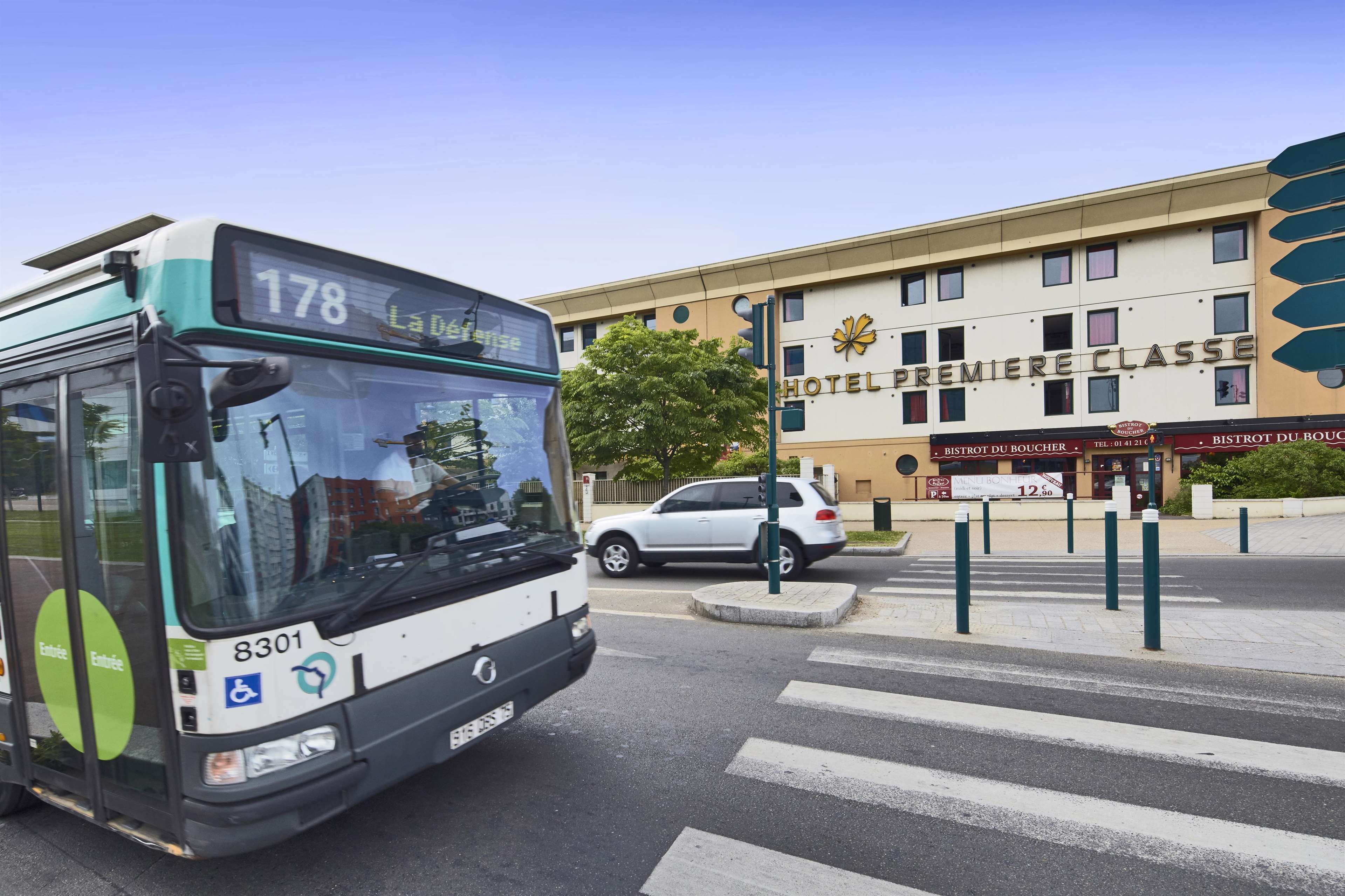 A bus with the number 178 and the destination 'La Dufourse' approaching a building with a sign reading 'HOTEL PREMIERE CLASSE'.