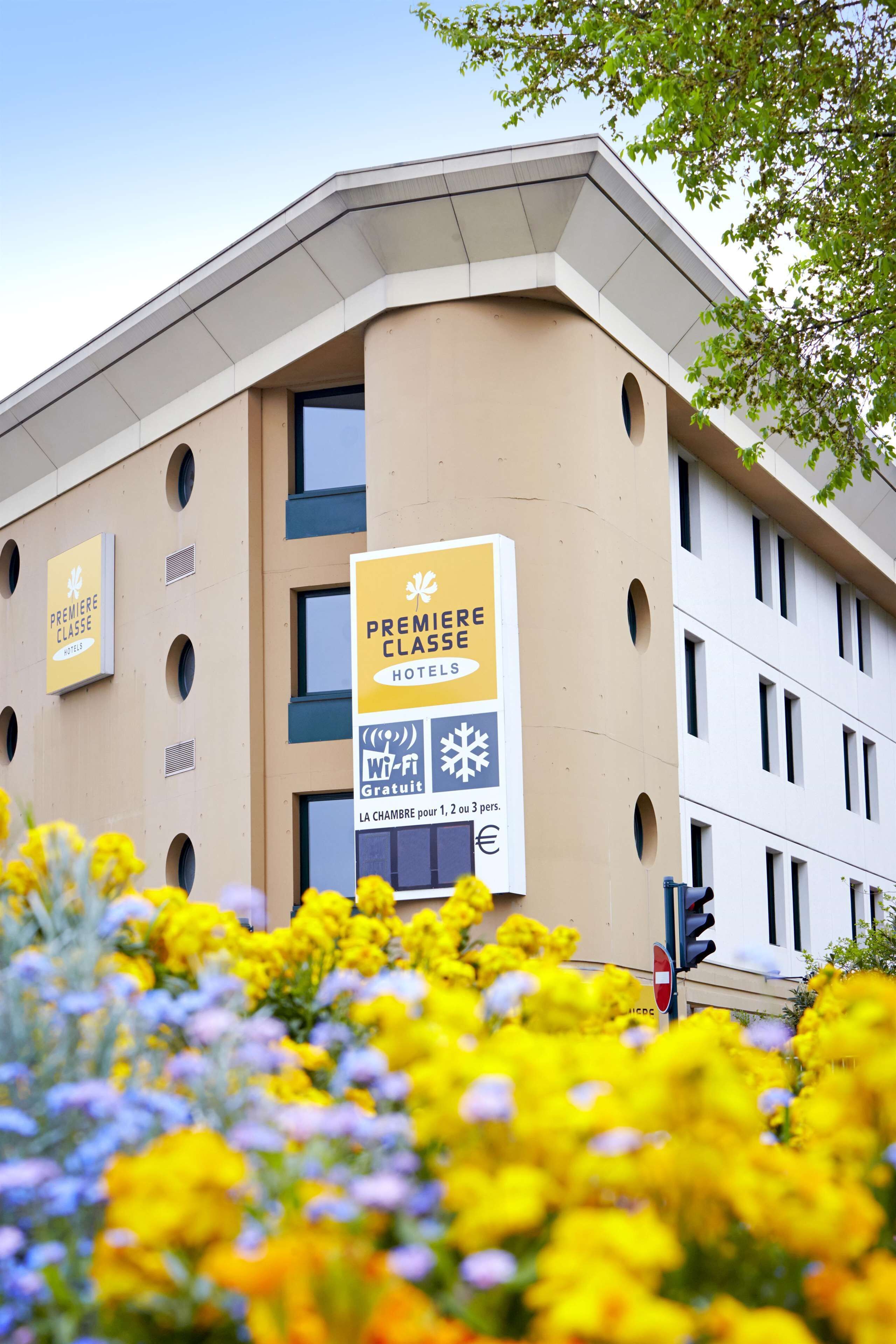 Un bâtiment d’hôtel avec une enseigne indiquant « Première Classe » et « Gratuit » pour la première chambre.