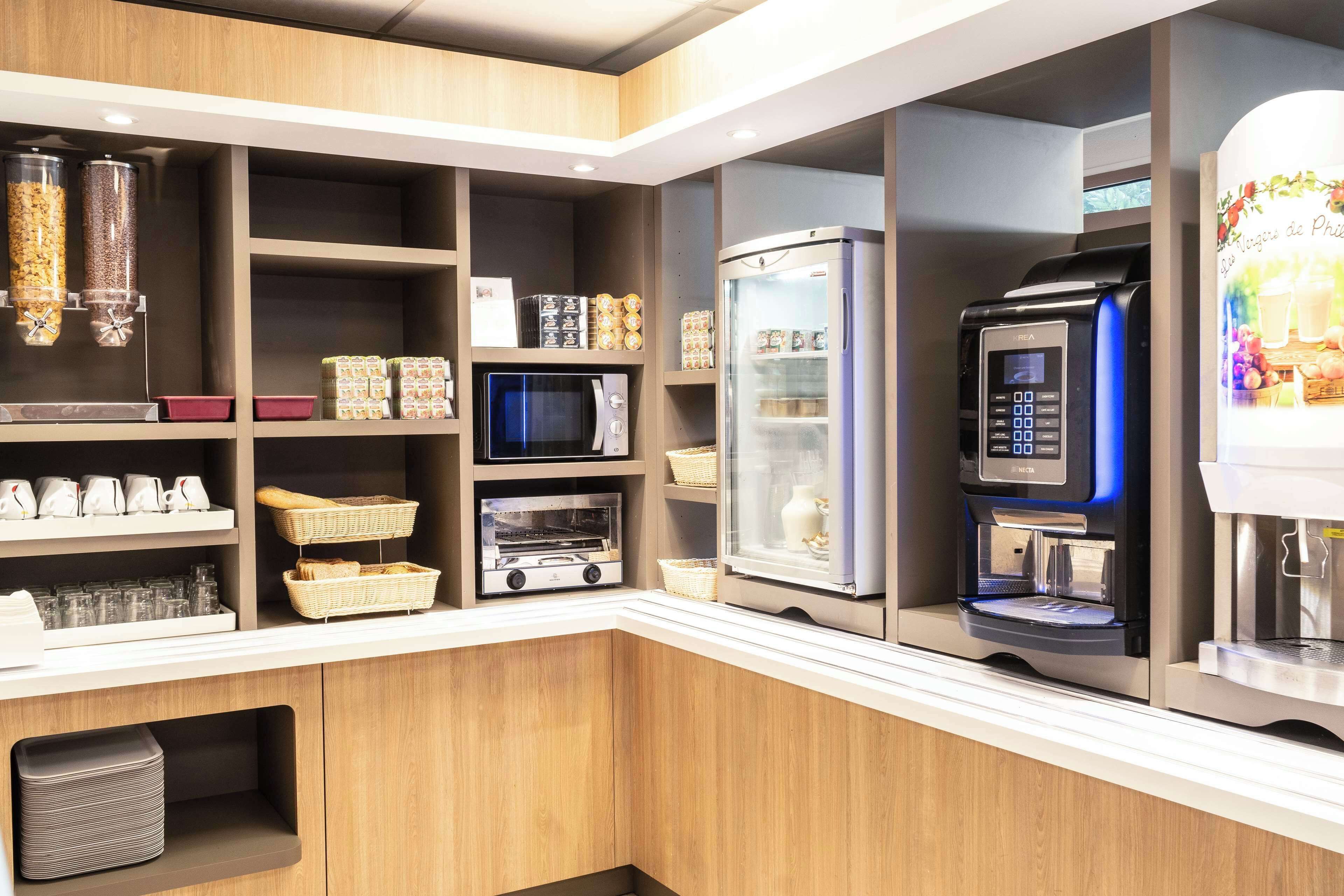 A modern kitchen with a microwave, oven, refrigerator, and coffee machine.