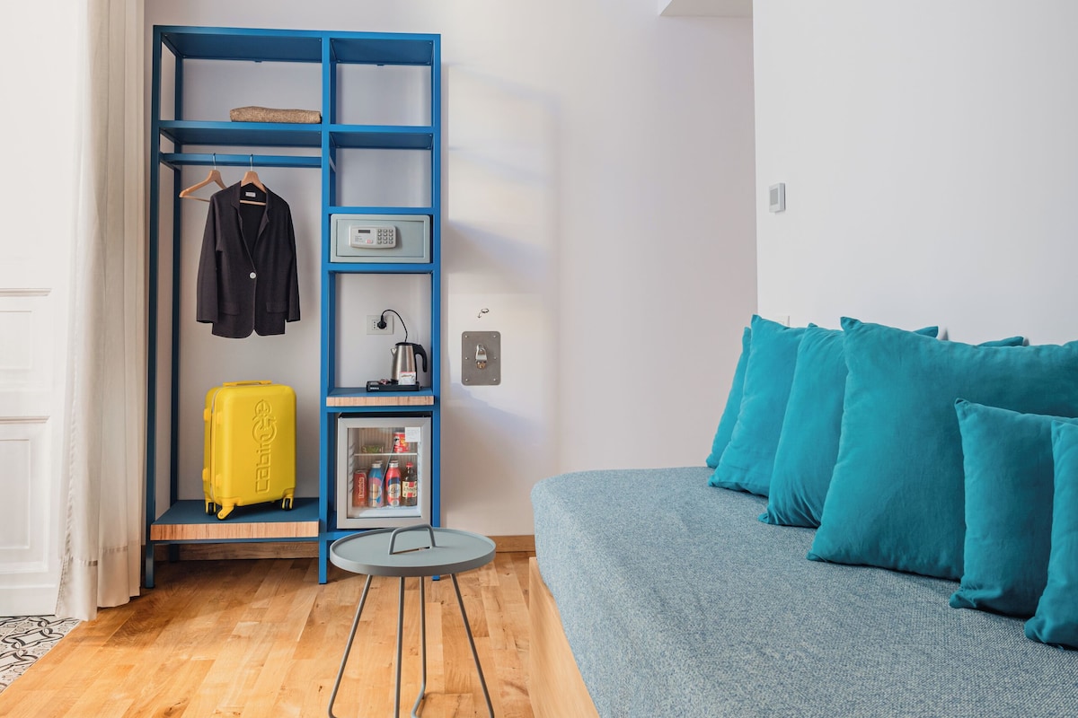 A modern room with a blue wardrobe, a grey sofa, and a small round table.