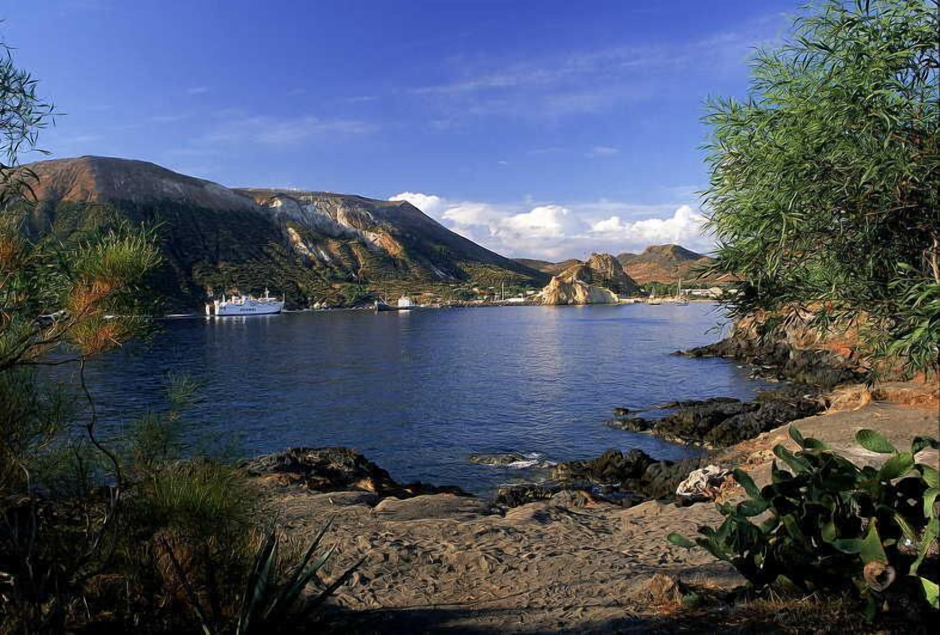 Ein ruhiger See mit einem Boot, umgeben von felsigem Gelände und spärlicher Vegetation.
