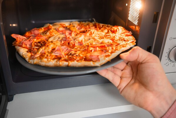 A pizza inside an oven with a timer visible.